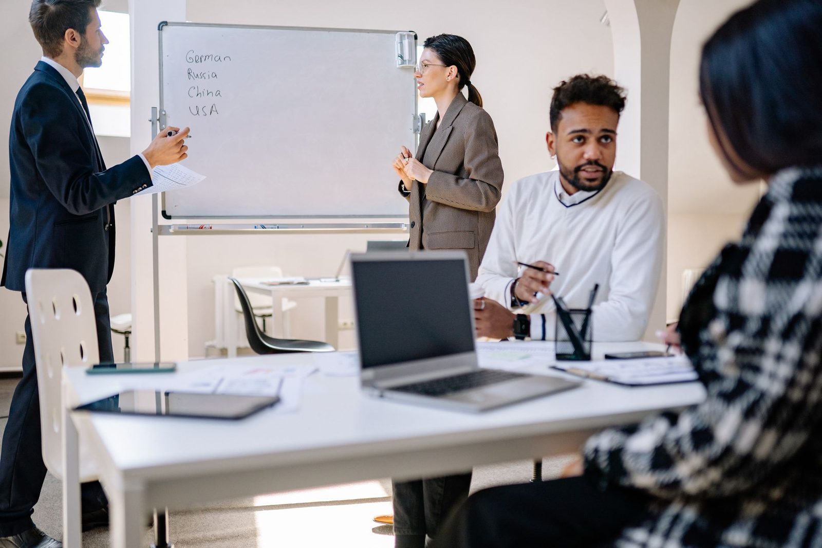 A small team working through a plan at a whiteboard in a shared office, the point at which a program picks a send volume and a tier