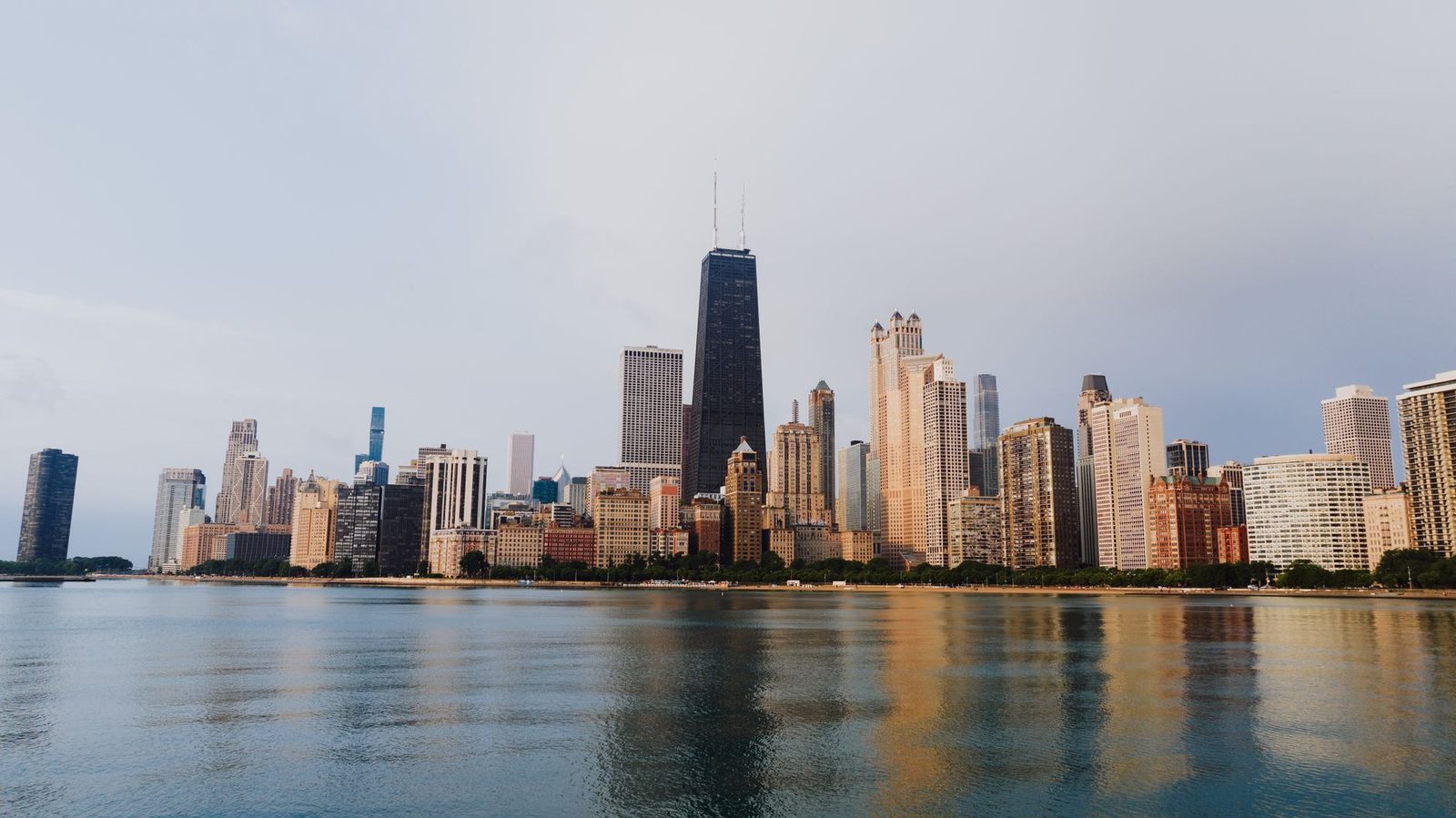The Chicago skyline with waterfront reflections under a clear sky, the largest media market an Illinois political SMS program covers