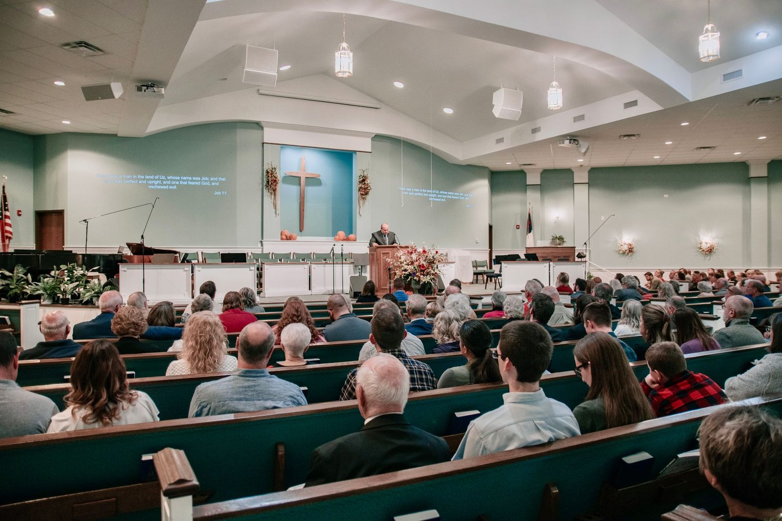 A congregation seated in a church, listening to a speaker