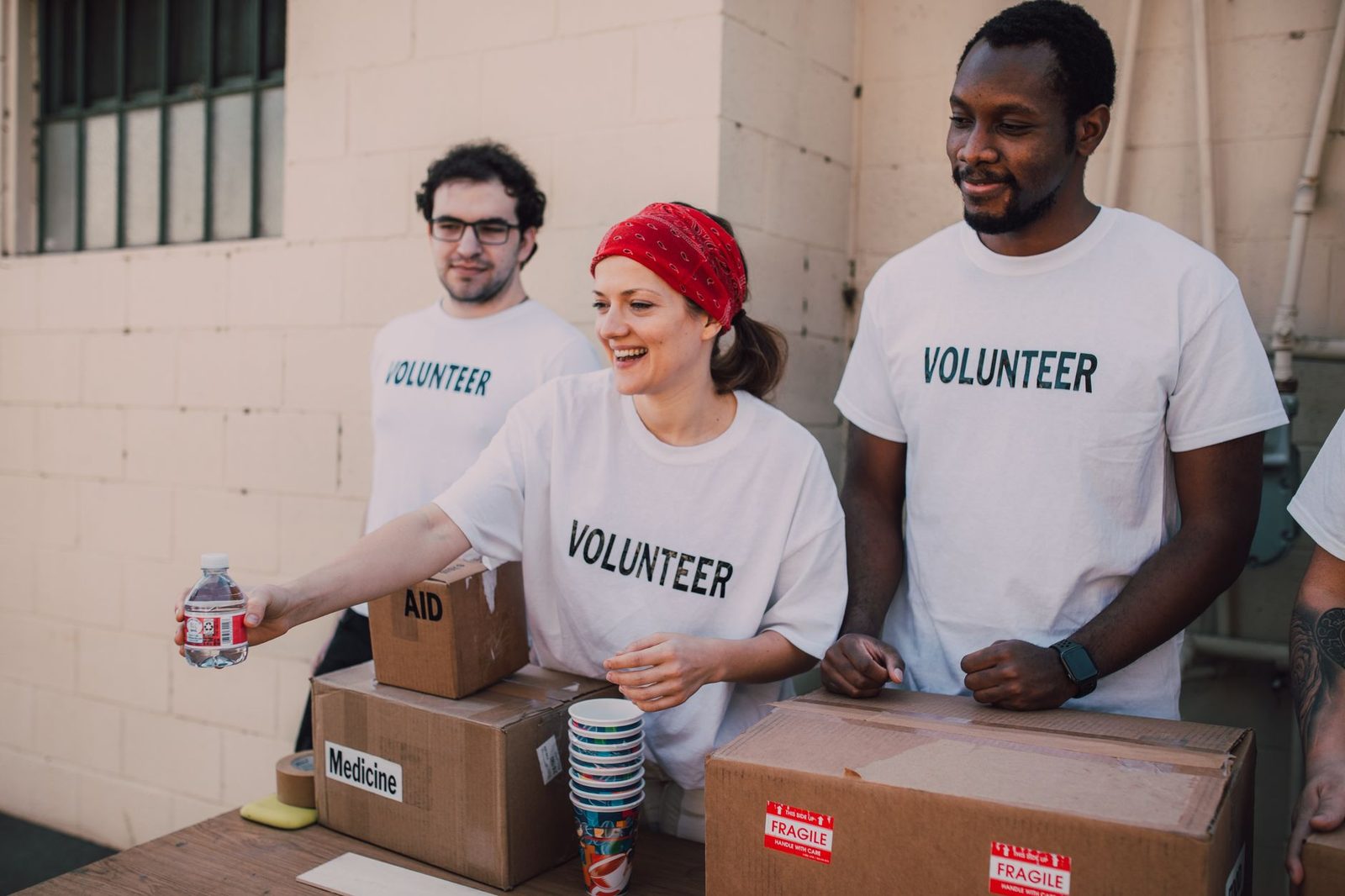 Volunteers in branded shirts sorting donation boxes at a community event