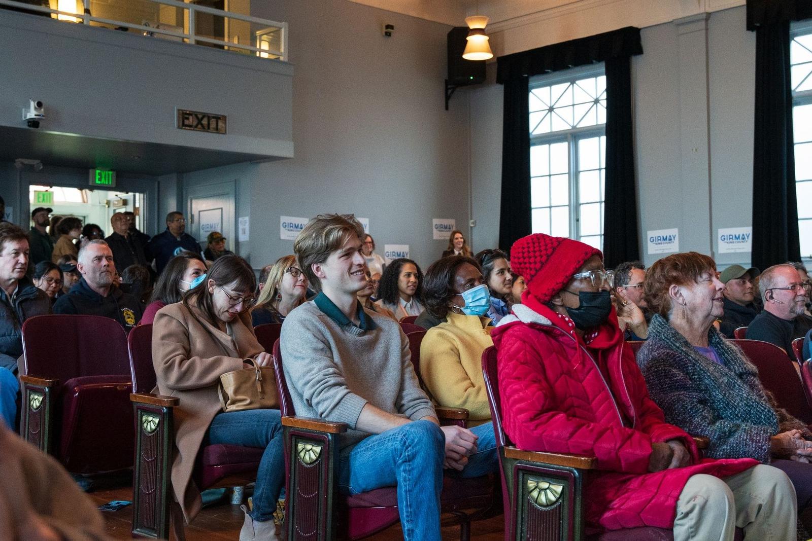 Residents seated at a local community meeting, the neighbourhood audience a campaign reaches by text