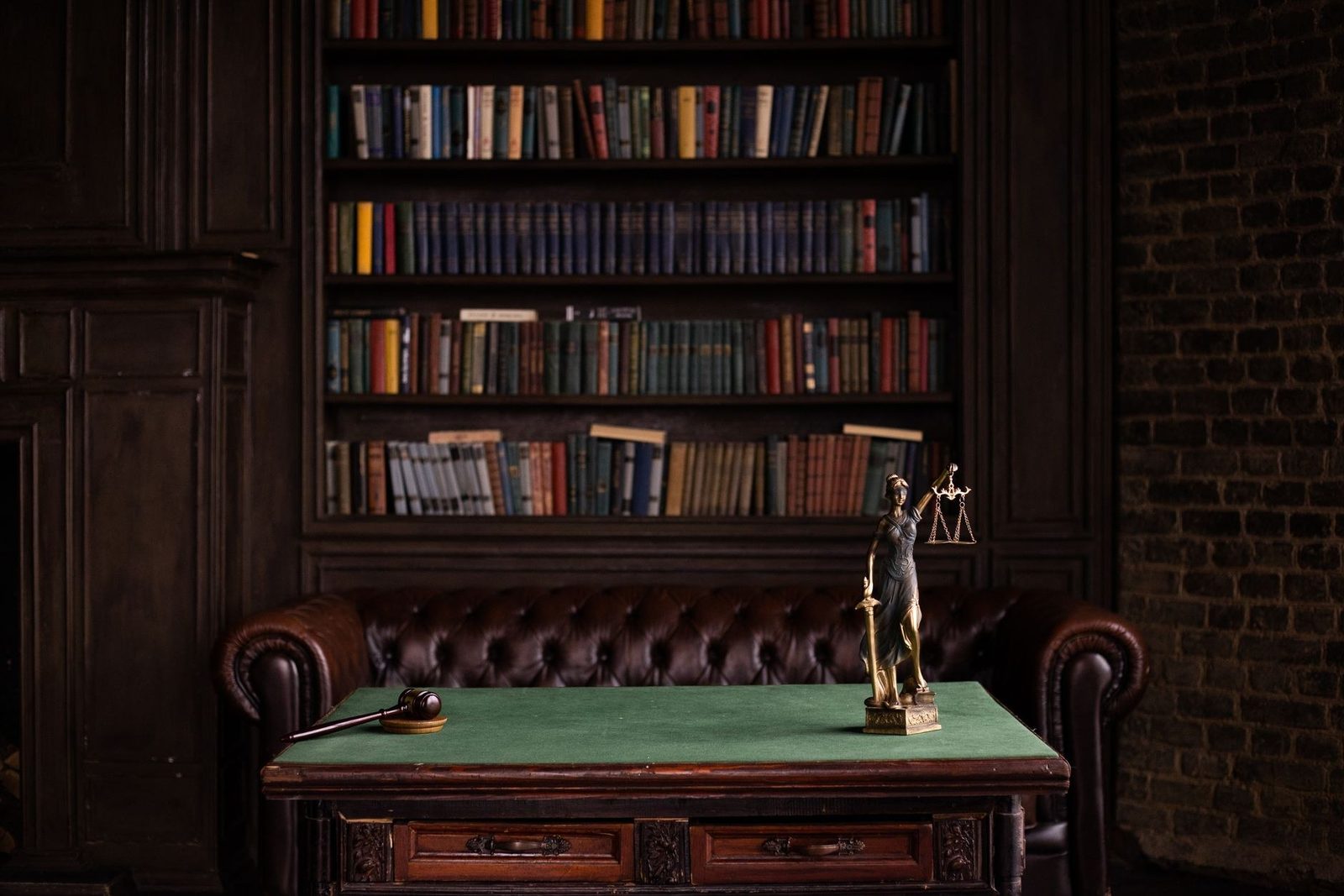 A law study with bookshelves, a gavel, and a figure of Lady Justice, the statutory-damages end of a non-compliant SMS program