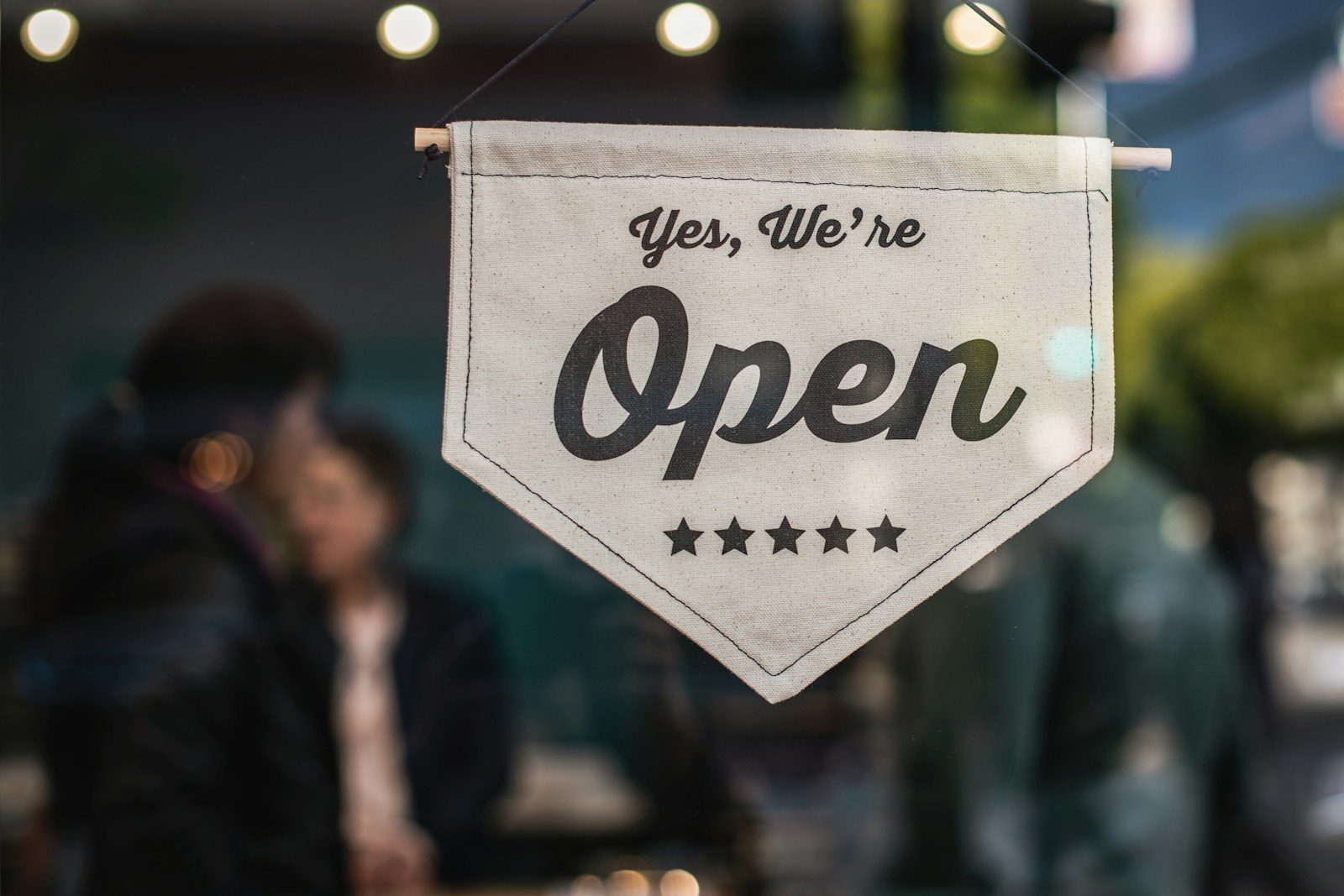 Open sign in a small-business storefront window, the kind of operation that runs SMS marketing on CampaignCNX+