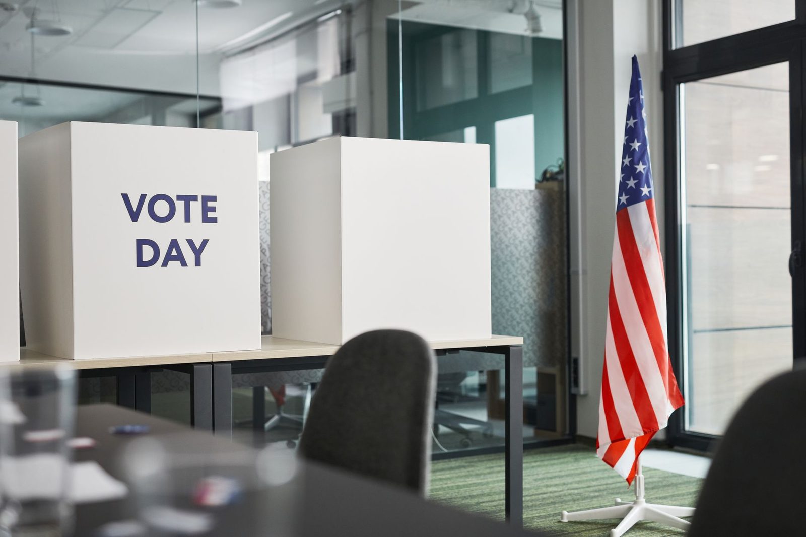 Voting booths marked Vote Day beside an American flag