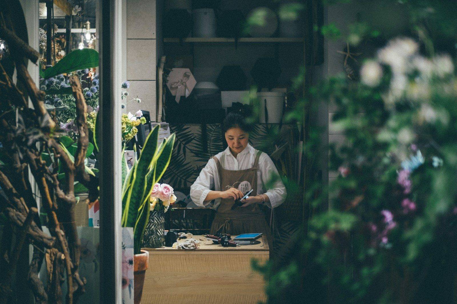 A small-business owner at the counter of a local shop, the kind of operation that runs business SMS marketing with CampaignCNX+