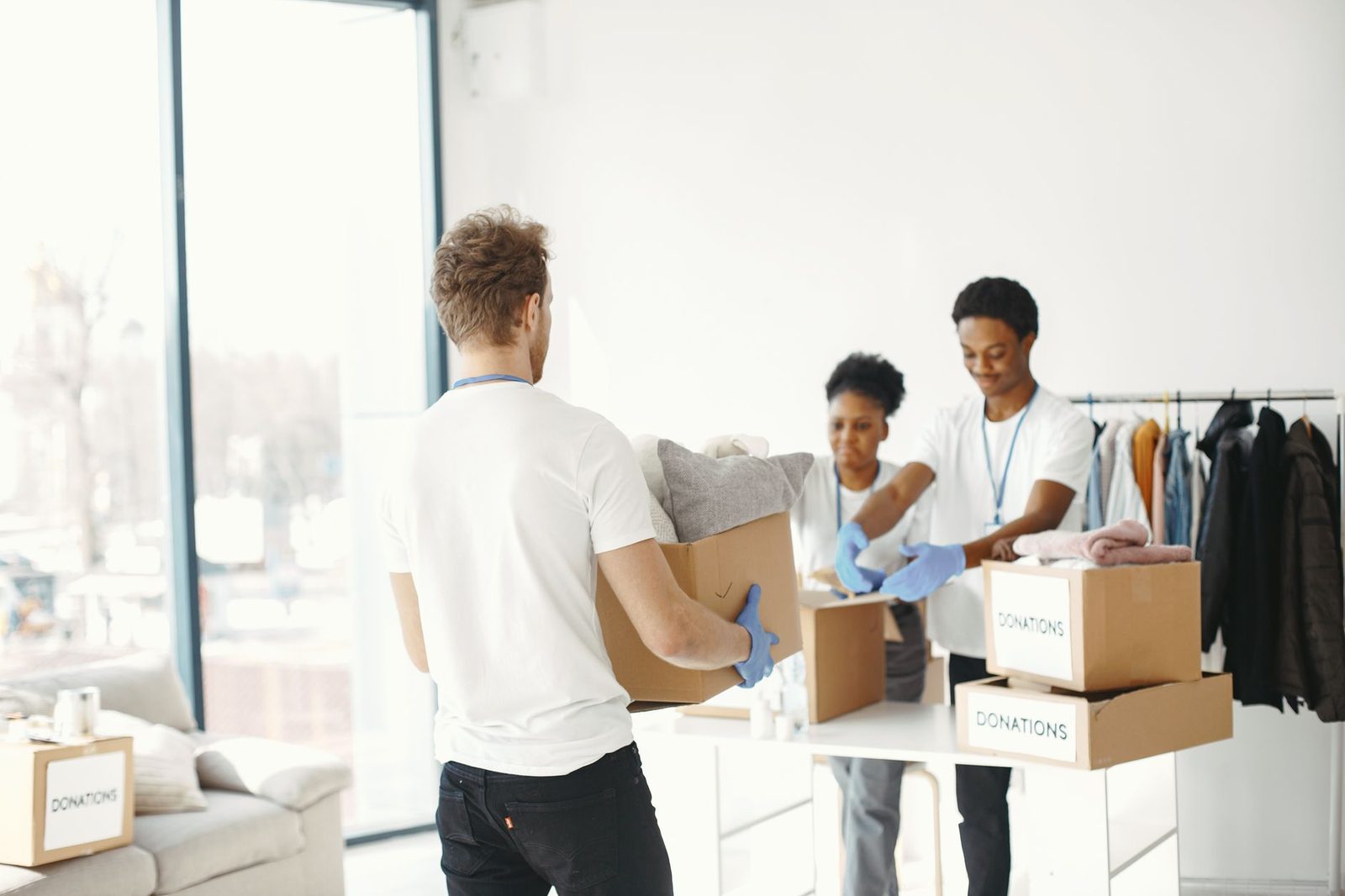 Volunteers packing clothes into boxes marked Donations