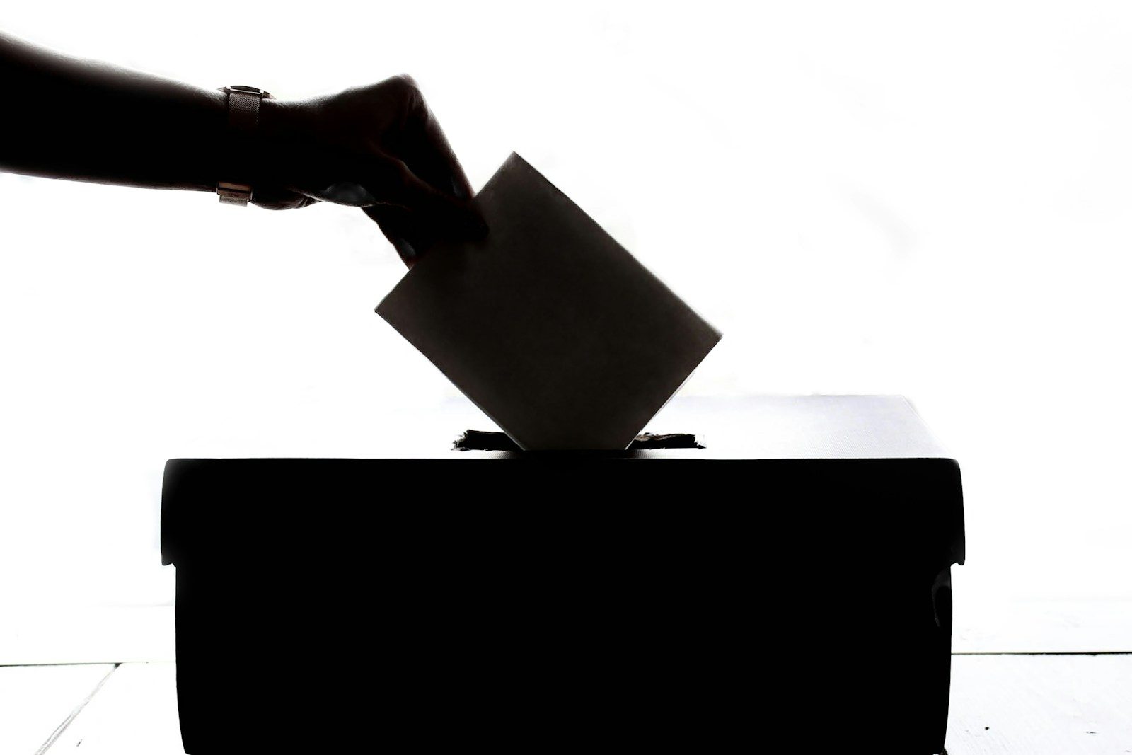 Voter casting a ballot at a polling place, the turnout a political SMS reminder program exists to move